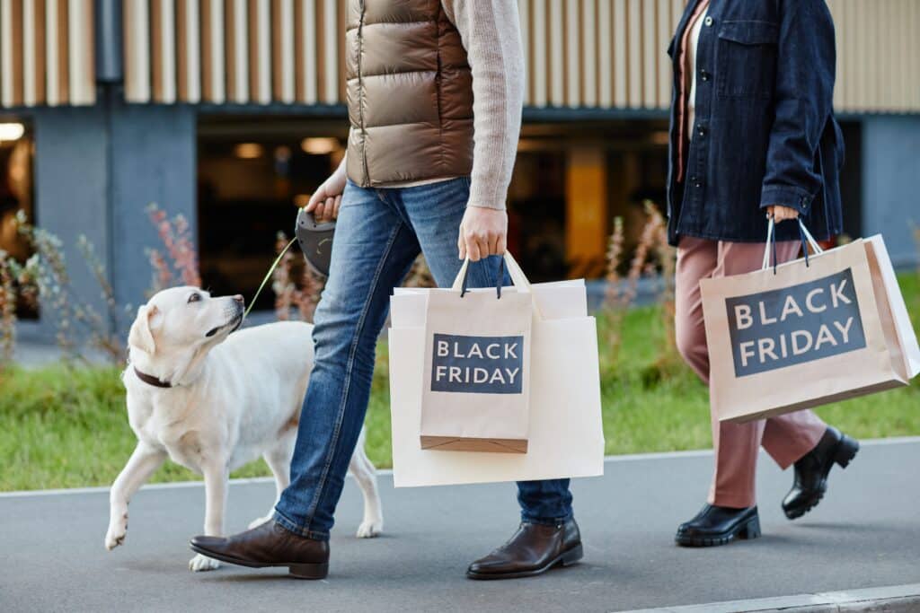 https://www.dogingtonpost.com/wp-content/uploads/2023/11/Adult-couple-holding-shopping-bags-with-Black-Friday-while-walking-outdoors-with-dog-1024x683.jpg