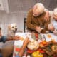 high angle view of golden retriever near family holding glasses of white wine during thanksgiving dinner